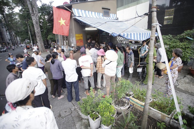 Ngọc Sơn phát tiền và gạo trước cửa cho người nghèo Sài Gòn